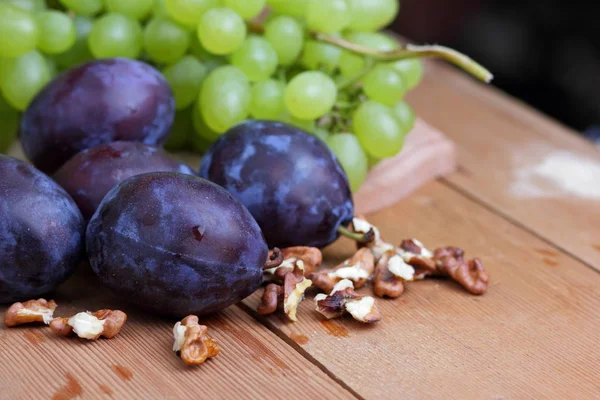 Виноград, рябина, дыня, орех и фиолетовые сливы на окне — стоковое фото