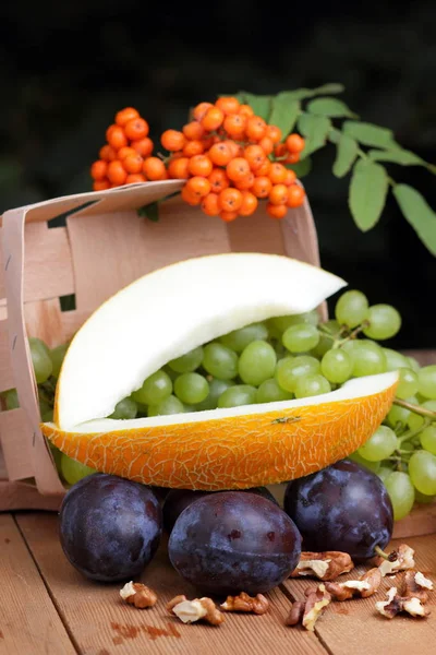 Winogrona, Jarzębina, melon, orzech i fioletowe śliwki na oknie — Zdjęcie stockowe