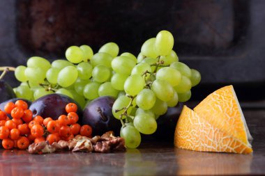 Erik, üzüm, üvez ve karanlık bir arka plan üzerinde ceviz