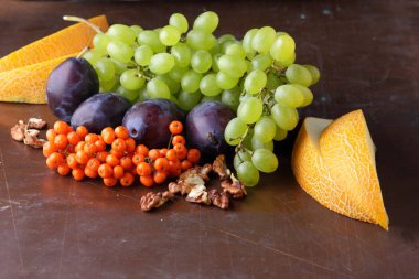 Erik, üzüm, üvez ve karanlık bir arka plan üzerinde ceviz