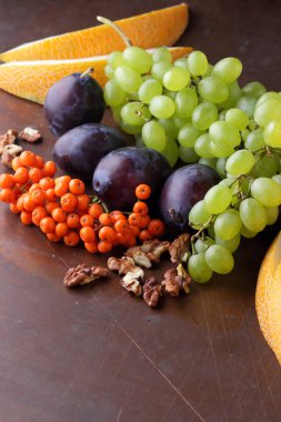 Erik, üzüm, üvez ve karanlık bir arka plan üzerinde ceviz