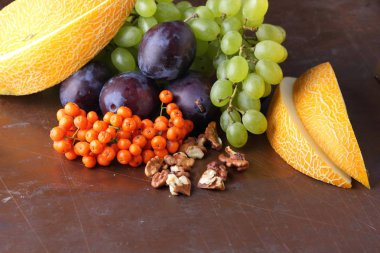 Erik, üzüm, üvez ve karanlık bir arka plan üzerinde ceviz