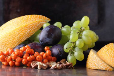 Erik, üzüm, üvez ve karanlık bir arka plan üzerinde ceviz