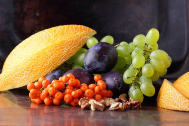 Erik, üzüm, üvez ve karanlık bir arka plan üzerinde ceviz