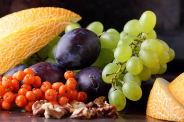 Erik, üzüm, üvez ve karanlık bir arka plan üzerinde ceviz