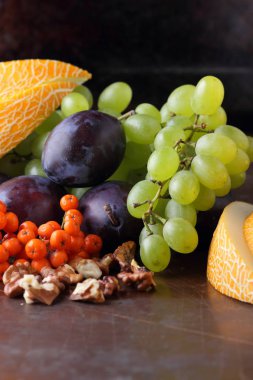 Erik, üzüm, üvez ve karanlık bir arka plan üzerinde ceviz