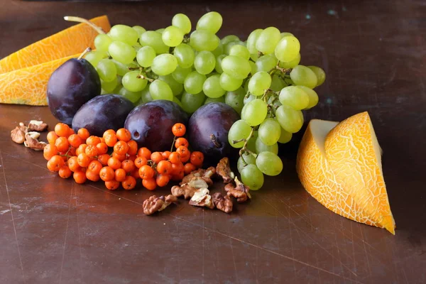 Erik, üzüm, üvez ve karanlık bir arka plan üzerinde ceviz