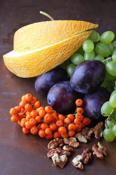 Erik, üzüm, üvez ve karanlık bir arka plan üzerinde ceviz