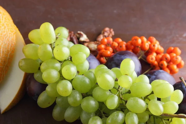 Erik, üzüm, üvez ve karanlık bir arka plan üzerinde ceviz