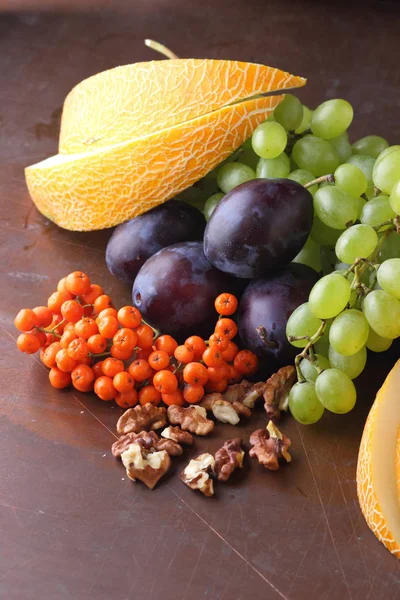 Erik, üzüm, üvez ve karanlık bir arka plan üzerinde ceviz