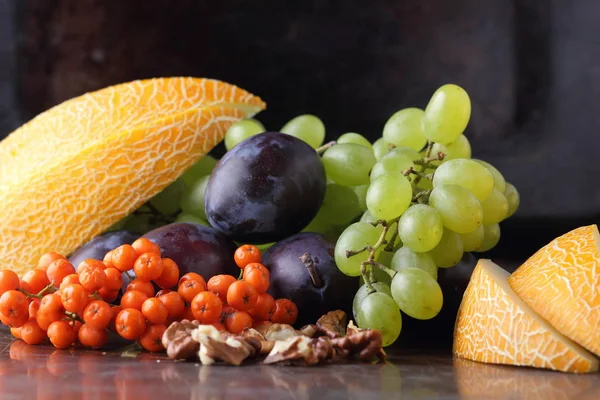 Erik, üzüm, üvez ve karanlık bir arka plan üzerinde ceviz