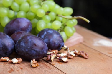 Yeşil üzüm, Erik, üvez, karpuz ve ceviz ahşap arka plan üzerinde