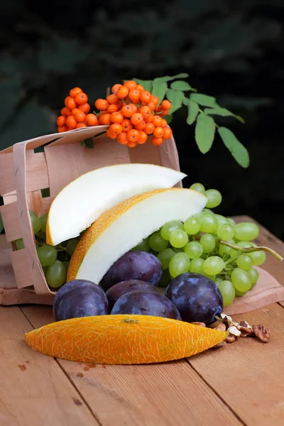 Yeşil üzüm, Erik, üvez, karpuz ve ceviz ahşap arka plan üzerinde