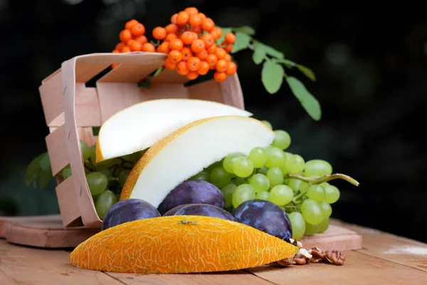 Zielone Winogrona Śliwki Jarzębina Melon Orzech Podłoże Drewniane — Zdjęcie stockowe