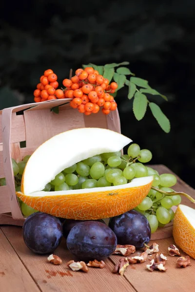 Yeşil üzüm, Erik, üvez, karpuz ve ceviz ahşap arka plan üzerinde