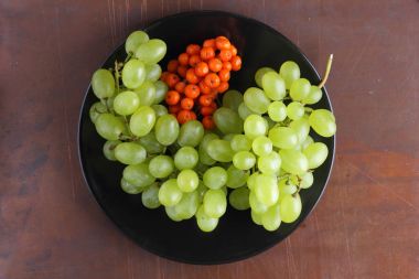 Yeşil üzüm, mavi Erik ve turuncu üvez meyveleri retro tarzı tasarımcısında için siyah bir plaka üzerinde