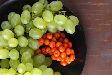 Yeşil üzüm, mavi Erik ve turuncu üvez meyveleri retro tarzı tasarımcısında için siyah bir plaka üzerinde