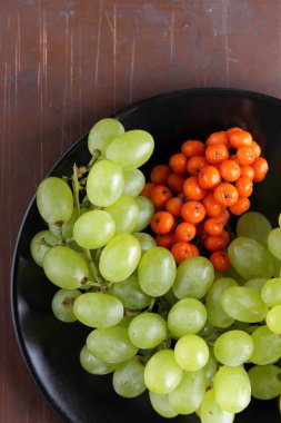 Yeşil üzüm, mavi Erik ve turuncu üvez meyveleri retro tarzı tasarımcısında için siyah bir plaka üzerinde