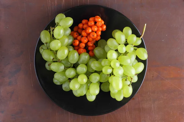 Yeşil üzüm, mavi Erik ve turuncu üvez meyveleri retro tarzı tasarımcısında için siyah bir plaka üzerinde