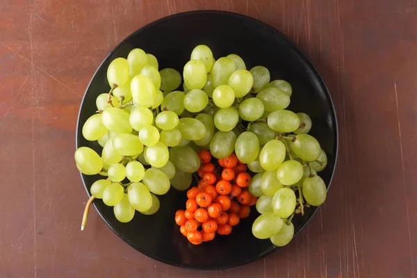 Yeşil üzüm, mavi Erik ve turuncu üvez meyveleri retro tarzı tasarımcısında için siyah bir plaka üzerinde
