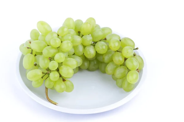 Uvas verdes em um fundo branco em uma chapa no estilo de minimalismo — Fotografia de Stock
