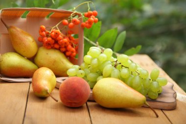 Armut, şeftali ve üvez meyveleri ahşap bir masa üzerinde mezarda ormanda hasat zaman