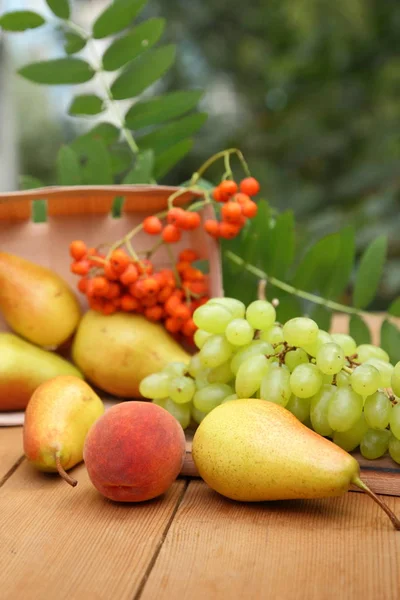 Armut, şeftali ve üvez meyveleri ahşap bir masa üzerinde mezarda ormanda hasat zaman — Stok fotoğraf