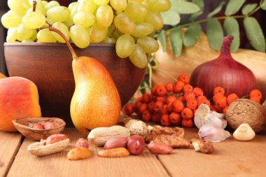 Armut, şeftali, Yeşil üzüm, üvez meyveleri, ceviz, fıstık, soğan, kabak, sarımsak hasadı sonra ahşap bir masa üzerinde