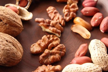 Ceviz ve beyaz bir arka plan üzerinde kahverengi kil tabakta fıstık