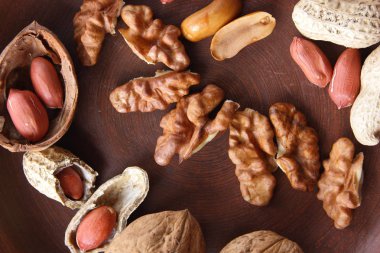 Ceviz ve beyaz bir arka plan üzerinde kahverengi kil tabakta fıstık