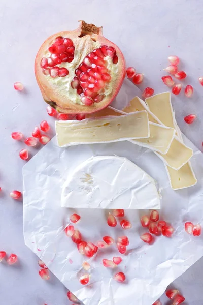 Camembert peyniri, peynir, peynir beyaz zemin üzerine nar taneleri ile bir sürü dilimlenmiş