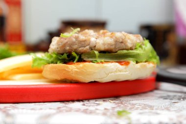 Dana eti, kırmızı domates, marul, peynir ve sos ev mutfak ile hamburger yemek