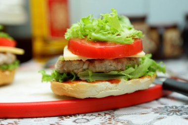 Dana eti, kırmızı domates, marul, peynir ve sos ev mutfak ile hamburger yemek