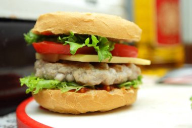 Dana eti, kırmızı domates, marul, peynir ve sos ev mutfak ile hamburger yemek
