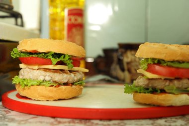 Dana eti, kırmızı domates, marul, peynir ve sos ev mutfak ile hamburger yemek