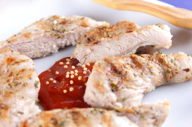 Biftek ızgara beyaz tabakta ahşap çatal, domates sosu, baharat ve retro tarzı koyu mavi zemin üzerine hardal taneleri ile