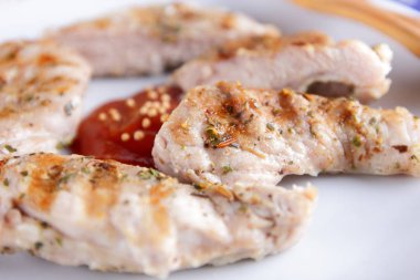 Biftek ızgara beyaz tabakta ahşap çatal, domates sosu, baharat ve retro tarzı koyu mavi zemin üzerine hardal taneleri ile