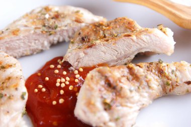 Biftek ızgara beyaz tabakta ahşap çatal, domates sosu, baharat ve retro tarzı koyu mavi zemin üzerine hardal taneleri ile