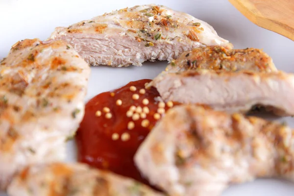 Biftek ızgara beyaz tabakta ahşap çatal, domates sosu, baharat ve retro tarzı koyu mavi zemin üzerine hardal taneleri ile