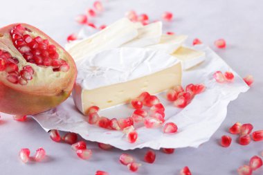 Camembert peyniri, peynir, peynir beyaz zemin üzerine nar taneleri ile bir sürü dilimlenmiş