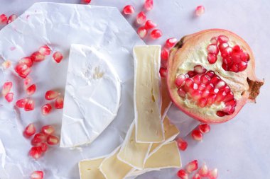 Camembert peyniri, peynir, peynir beyaz zemin üzerine nar taneleri ile bir sürü dilimlenmiş