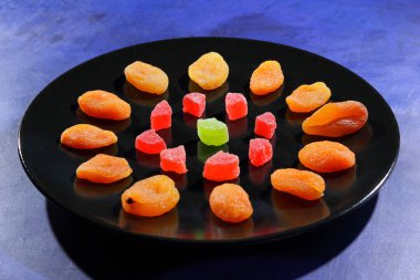 Kuru Kayısı, şekerlenmiş meyve şeker retro tarzı bir koyu mavi arka plan üzerinde siyah bir plaka üzerinde