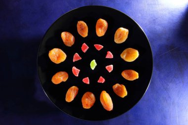 Kuru Kayısı, şekerlenmiş meyve şeker retro tarzı bir koyu mavi arka plan üzerinde siyah bir plaka üzerinde