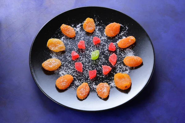 Kuru Kayısı, şekerlenmiş meyve şeker retro tarzı bir koyu mavi arka plan üzerinde siyah bir plaka üzerinde