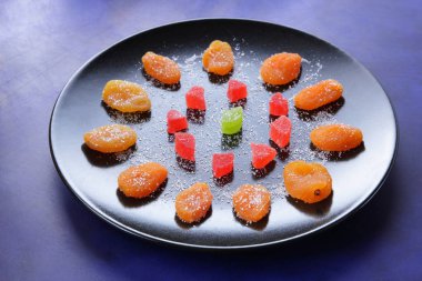 Kuru Kayısı, şekerlenmiş meyve şeker koyu mavi zemin üzerine siyah bir plaka üzerinde