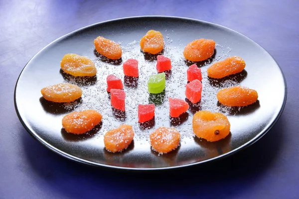 Kuru Kayısı, şekerlenmiş meyve şeker koyu mavi zemin üzerine siyah bir plaka üzerinde