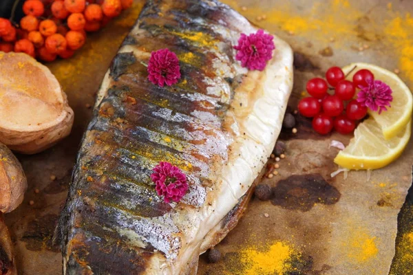 Grillezett hal, sajt, méz, berkenye, kalina, citromos szelet, sült burgonya, rózsaszín virágok és fűszerek a pergamen papír — Stock Fotó