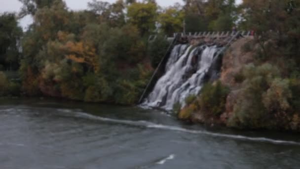 Вода течет через гранитные камни рукотворного водопада на острове — стоковое видео