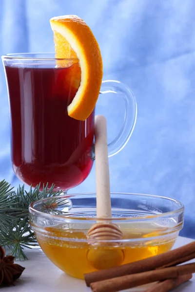 Vino caliente de Navidad con rodajas de naranja, vino caliente con canela y anís, bebida con miel, vino caliente sobre fondo azul claro y blanco, estilo retro —  Fotos de Stock