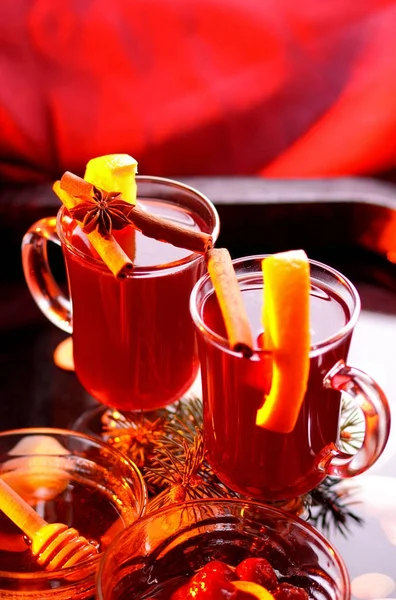 Christmas mulled wine in water, mulled wine with cinnamon and anise, drink with honey, mulled wine glass with seashells in water, retro style, drink with orange slices